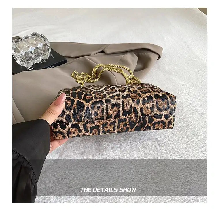Carauana_UNIU_Leopard_Clutch held by a hand on a neutral background