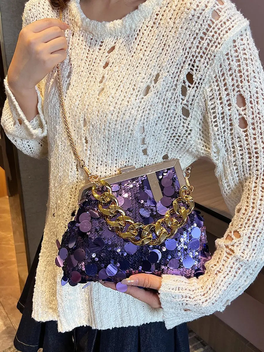 Person holding a purple sequin handbag with gold chain detail