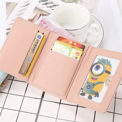 Pink wallet with cartoon character card holder on a white surface