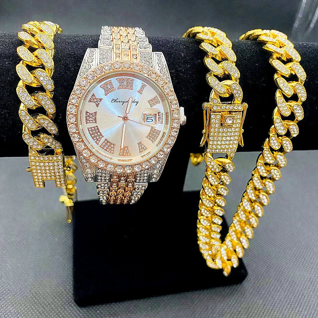 Gold watch and bracelet set on a black stand