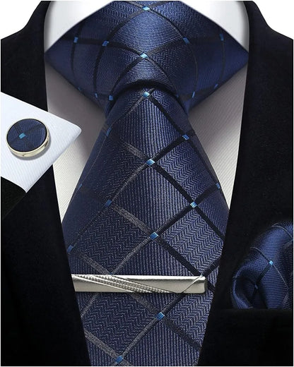 Navy blue patterned tie with a silver clip on a white shirt with black lapels.