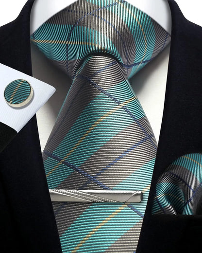 Teal and gray plaid tie with matching pocket square and cufflinks on a black suit.