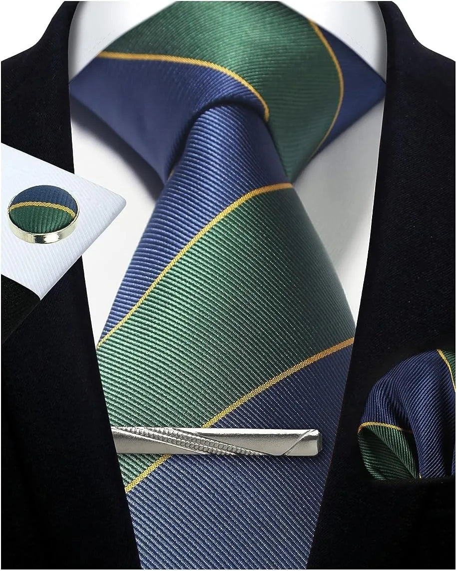Navy and green striped tie with matching pocket square and tie clip on a white shirt.