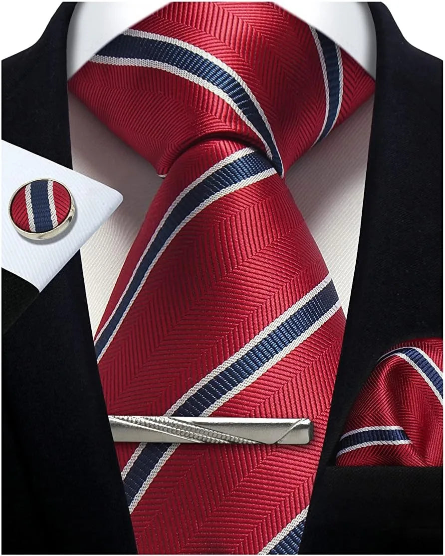 Red tie with blue and white stripes, cufflinks, and tie clip on a suit jacket.