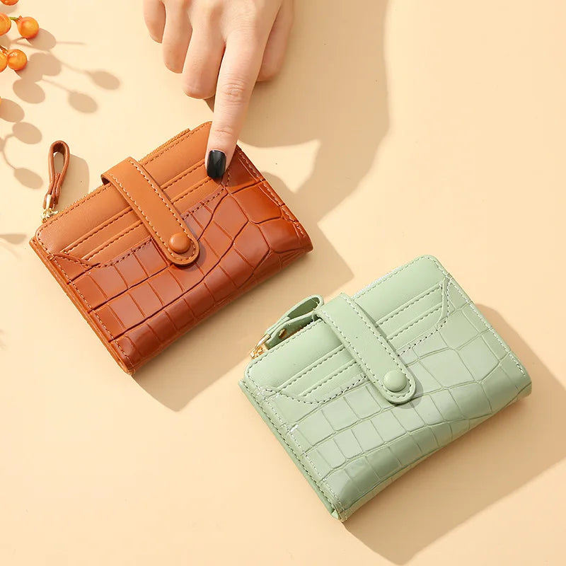 Two wallets, one brown and one green, on a beige background.