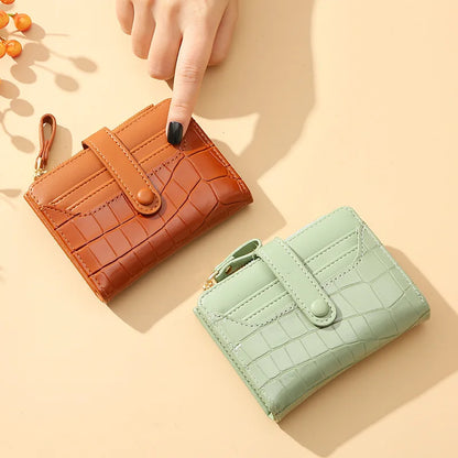 Two wallets, one brown and one green, on a beige background.